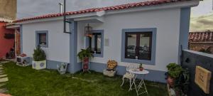 a small white house with a table and chairs at Casa Odélia in Almargem do Bispo