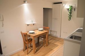 a small kitchen with a wooden table and chairs at Domu 600 - Suite mini appartamento Cagliari centro storico in Cagliari