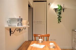 una cucina con tavolo in legno e sedia di Domu 600 - Suite mini appartamento Cagliari centro storico a Cagliari