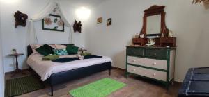 a bedroom with a bed and a dresser and a mirror at Casa Odélia in Almargem do Bispo