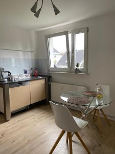 uma cozinha com uma mesa de vidro, uma mesa e cadeiras em Tolle Ferienwohnung 34 qm Netflix Prime em Bochum