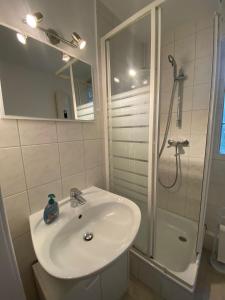 uma casa de banho branca com um lavatório e um chuveiro em Tolle Ferienwohnung 34 qm Netflix Prime em Bochum