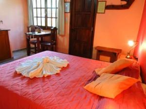 a red bed with a dress on top of it at Complejo Mi Viejo Vicente in Merlo