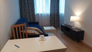 een woonkamer met een blauwe bank en een tafel bij Apartament Sztygara in Mikołów