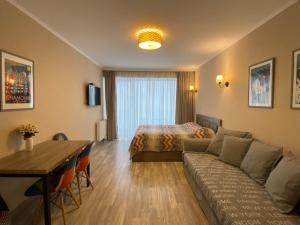 a hotel room with a bed and a couch and a table at New Gudauri Alpen Apartments in Gudauri