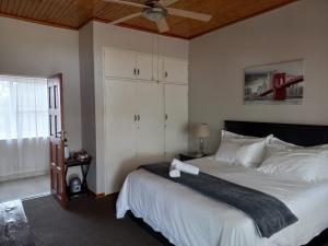 um quarto com uma cama e uma ventoinha de tecto em The Lakehouse BnB em Brakpan