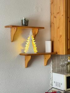 a wooden shelf with a christmas tree on a wall at Monolocale la terrazza sulla neve-Cervinia in Breuil-Cervinia +7 photos