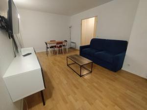 ein Wohnzimmer mit einem blauen Sofa und einem Tisch in der Unterkunft Pantin appartement en rez-de-chaussée in Pantin