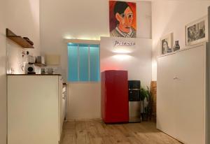 Habitación con nevera roja y una pintura en la pared. en Sunrise Estudio Picasso, con vistas jardín y mar, en Miami Platja