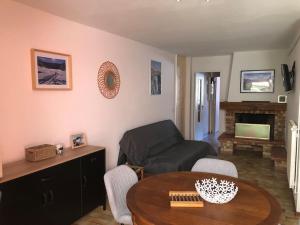 - un salon avec une table et un canapé dans l'établissement Joli appartement avec terrasse et jardin - vue sur montagne, à Bagnères-de-Bigorre
