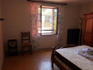 - une chambre avec un lit, une fenêtre et une chaise dans l'établissement Joli appartement avec terrasse et jardin - vue sur montagne, à Bagnères-de-Bigorre