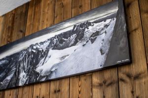 une photo d'une montagne sur un mur en bois dans l'établissement Mountain Break coeur du Val Claret pieds des pistes- Tignes - Lit queen size, à Tignes
