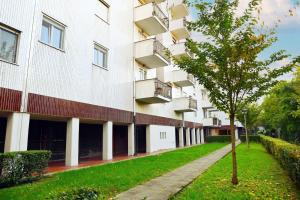 un bâtiment avec un arbre en face dans l'établissement Lucca 22, à Milan