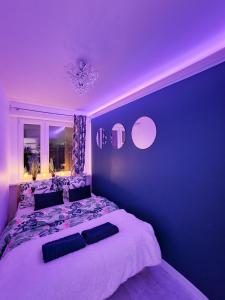 a purple bedroom with a large bed and a window at Apartament Green Mrągowo-Mazury,blisko plaża, centrum! Wi-fi! in Mrągowo