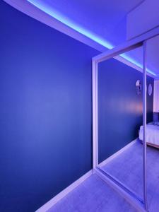 a room with a blue wall with a glass door at Apartament Green Mrągowo-Mazury,blisko plaża, centrum! Wi-fi! in Mrągowo