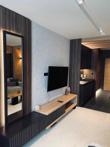 sala de estar con TV de pantalla plana en la pared en Woodside Apartman Kopaonik 315 en Kopaonik