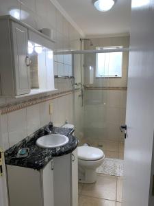 y baño con lavabo y aseo. en Residencial Atenas I, en Bombinhas