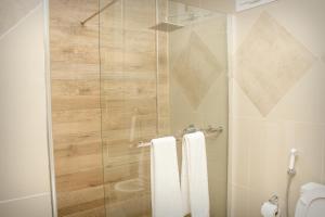 a bathroom with a shower with a glass door at Rosewood by Amaryllis Lilongwe in Lilongwe +18 photos