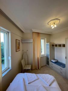 a bedroom with a large white bed and a window at Excellent 3 storey villa with a swimming pool in Belek