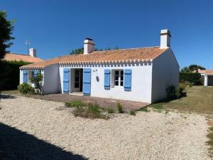 een klein wit huis met blauwe luiken bij Maison Noirmoutrine agréable de 3 chambres avec grand jardin in Le Grand Vieil