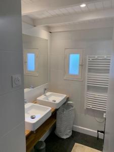 een witte badkamer met 2 wastafels en een spiegel bij Maison Noirmoutrine agréable de 3 chambres avec grand jardin in Le Grand Vieil