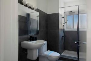 a bathroom with a sink and a toilet and a shower at Urban Condo 43 - 1 Bdr in Nicosia
