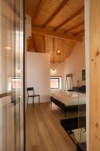 1 dormitorio con 1 cama y pared de cristal en Casa da Viela en Bragança