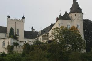 ein Schloss auf einem Hügel mit Bäumen davor in der Unterkunft Hotel Vinothek Schwarzer Adler in Ottensheim