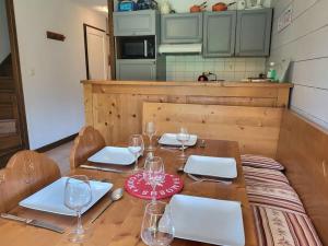 un tavolo in legno con bicchieri da vino sopra di Cascades, 3 bedroom chalet with shared pool. a Samoëns