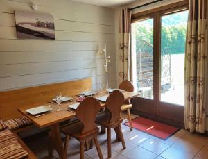 una sala da pranzo con tavolo, sedie e finestra di Cascades, 3 bedroom chalet with shared pool. a Samoëns