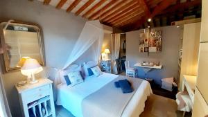 Un dormitorio con una cama blanca y un espejo. en Massacan-Vue Mer, en Le Lavandou