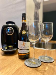 una bottiglia di vino e due bicchieri di vino su un tavolo di Platzhirsch a Kehl am Rhein