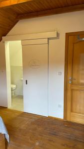 a bathroom with a sliding door and a toilet at Guest House Alpha Ski Camp in Jahorina