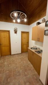 una cocina con armarios de madera y fregadero en Guest House Alpha Ski Camp, en Jahorina