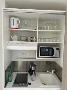 a kitchen with a microwave and a sink at Plaisir Caraïbes in Belle-Allée