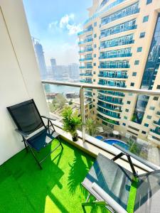 Super Elegant studio apartment-Sparkle tower By SWEET HOMES في دبي: شرفة مع كراسي وإطلالة على مبنى