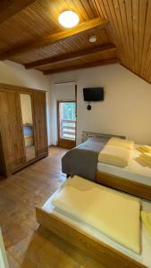 a bedroom with two beds and a flat screen tv at Guest House Alpha Ski Camp in Jahorina