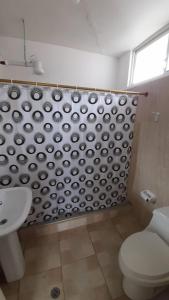 a bathroom with a toilet and a shower curtain at El Paraiso in Puerto Ayora