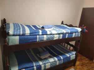 two bunk beds with a blue and white quilt at Branka in Surčin