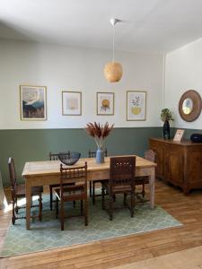- une salle à manger avec une table et des chaises en bois dans l'établissement Maison chaleureuse avec piscine, 