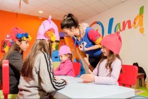 Un groupe de filles portant des chapeaux roses à une table dans l'établissement Olimpic Village TH Sestriere apartments, à Sestrières