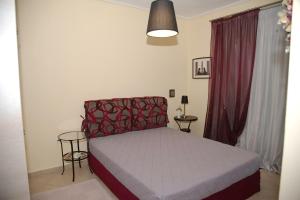 een slaapkamer met een bed met een rode en witte sprei bij ΜΕΖΟΝΕΤΑ 120 τ.μ. in Kalabaka