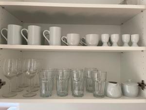 a row of glasses and cups on a shelf at VIC Apartment in Vienna