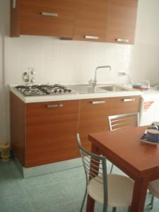 a kitchen with a stove and a sink and a table at Bivani sul porto vecchio in Lampedusa