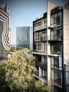 un edificio de apartamentos con un árbol delante de él en Acogedor y moderno departamento, en Ciudad de México