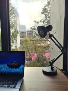 escritorio con micrófono y ordenador portátil en Acogedor y moderno departamento, en Ciudad de México
