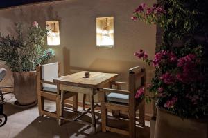 a wooden table and chairs in a room with flowers at Riad Dar Eternity in Marrakech