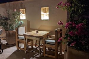 a wooden table and chairs in a room with flowers at Riad Dar Eternity in Marrakesh