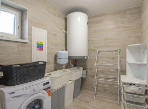 - une buanderie avec un lave-linge et un tabouret dans l'établissement Velký apartmán Zlámanka, à Kroměříž