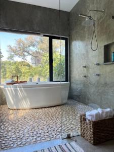 墨西哥城的住宿－Mi Refugio San Angel，带浴缸的浴室和大窗户